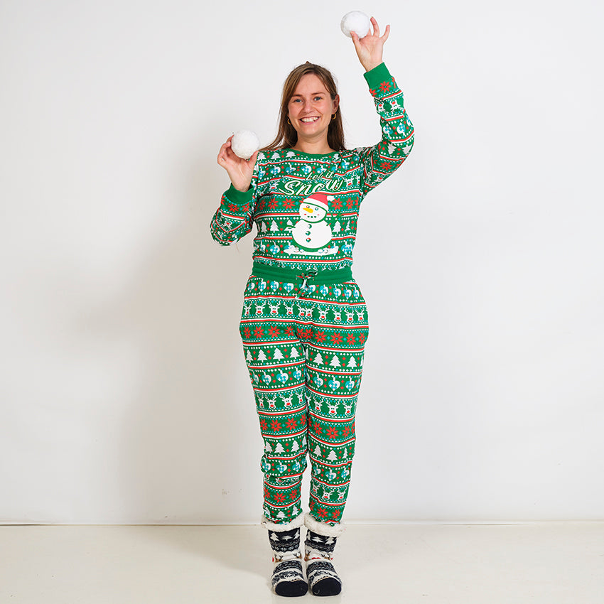 Eine Frau trägt einen grünen Weihnachtspyjama mit einem Schneemann darauf.